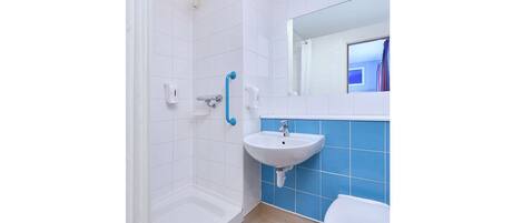 Un baño con ducha, lavabo e inodoro.