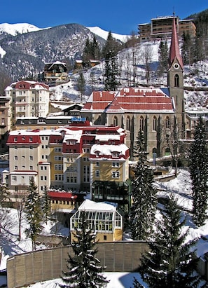 A snow-covered town with a prominent church and several multi-story buildings. - Hotel Sanotel (Bad Gastein)