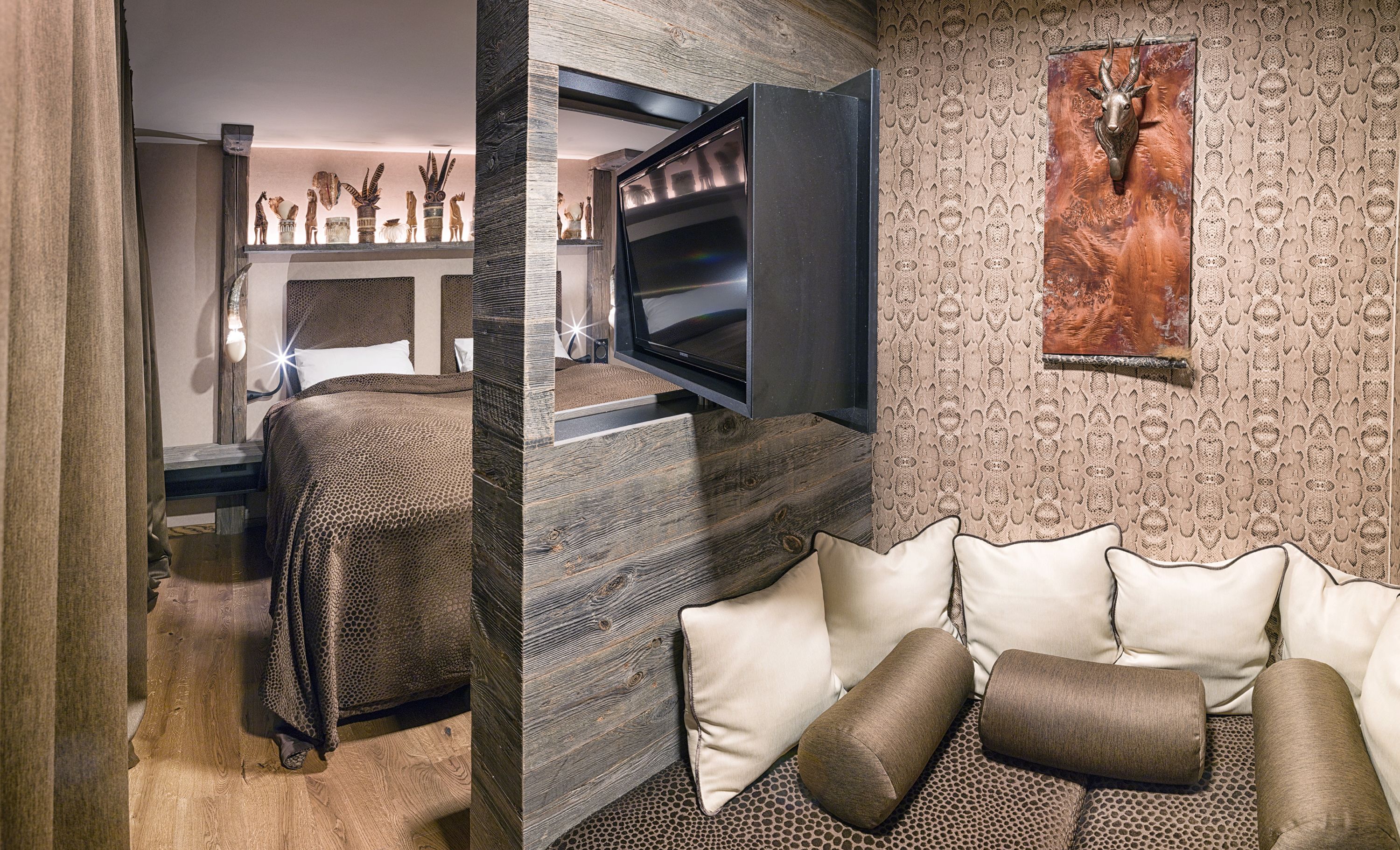 Ein modernes Schlafzimmer mit Bett, Fernseher und Wanddekoration.