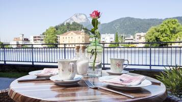 Ein Tisch für zwei mit Blick auf einen Berg und einen Fluss.