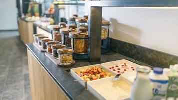 A buffet setup with various food items and condiments.