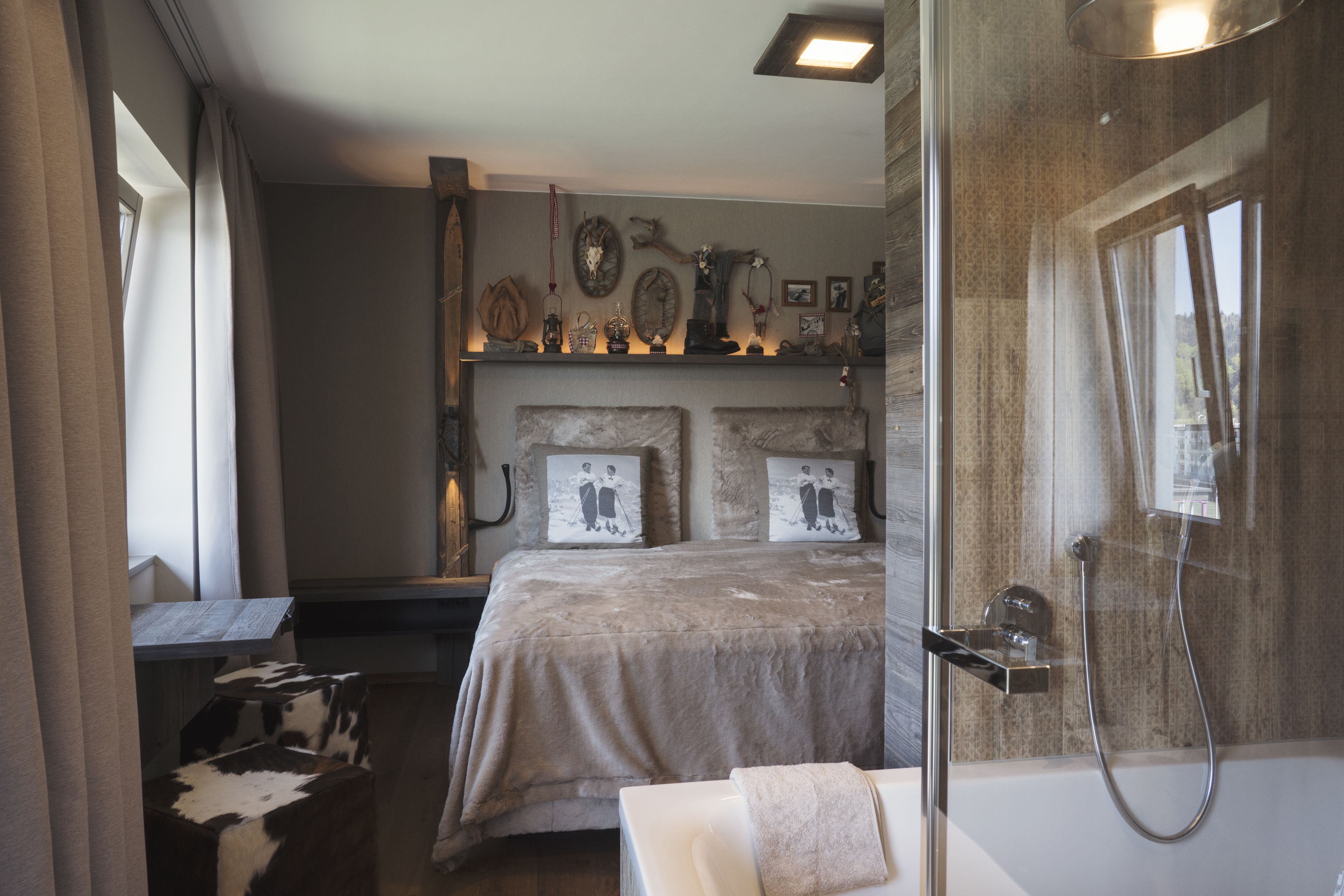 Ein Schlafzimmer mit einem großen Bett, einem Nachttisch, einem Spiegel und einem Duschbereich.