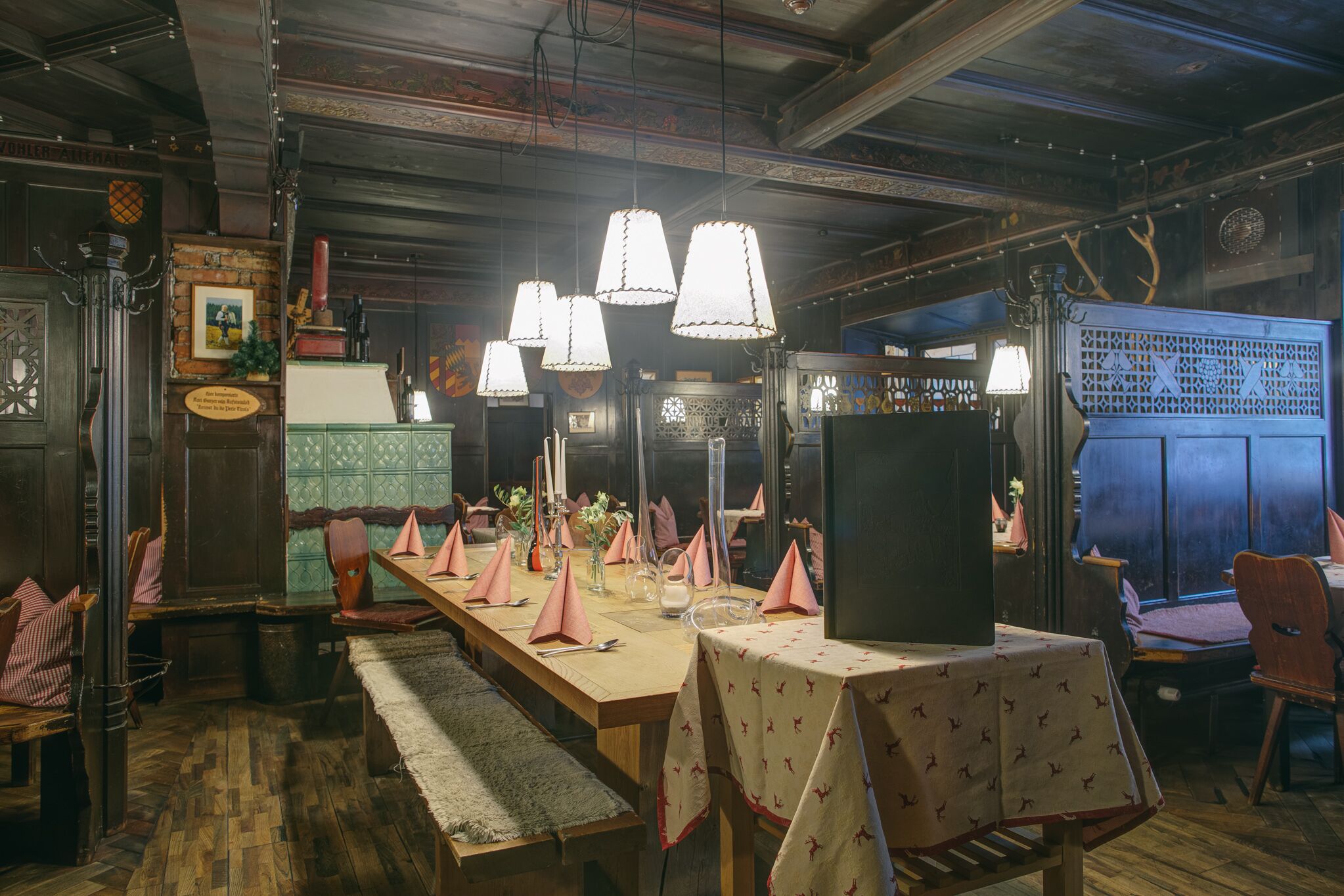A dining area with a long wooden table set for a meal, surrounded by chairs.