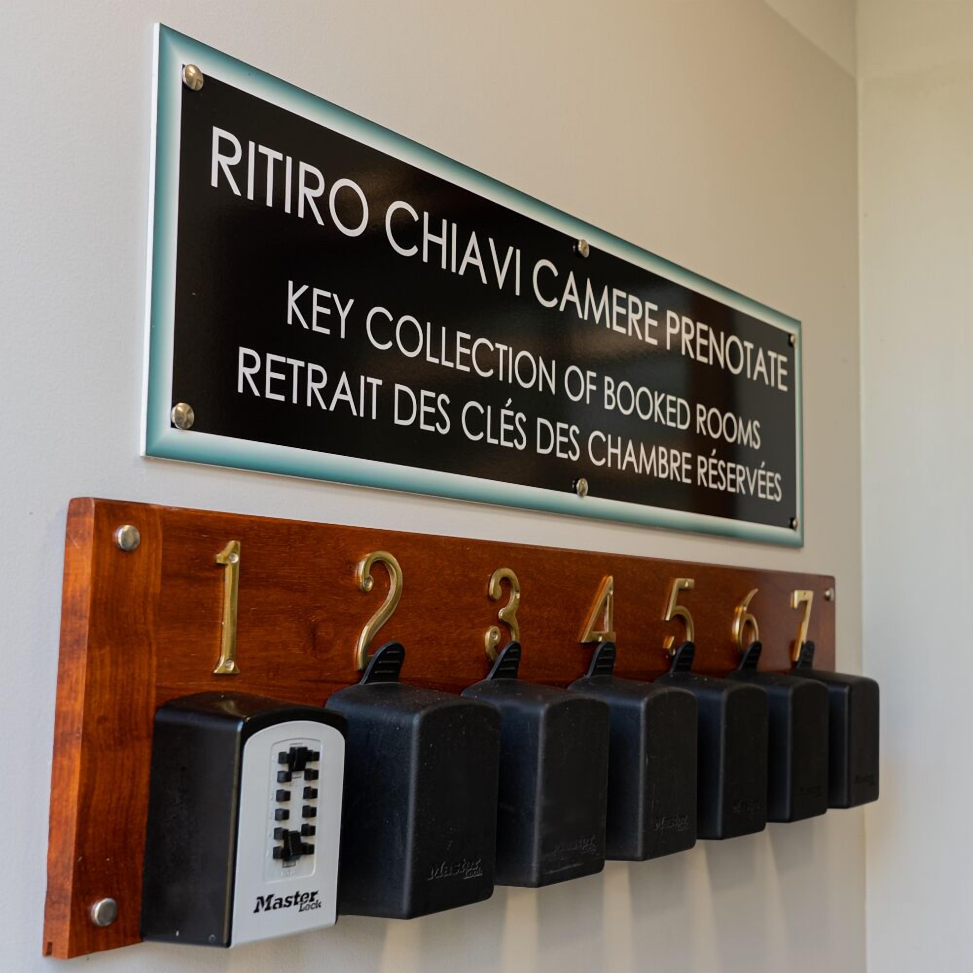 A sign indicating a key collection point for booked rooms and a Master Lock for room keys.