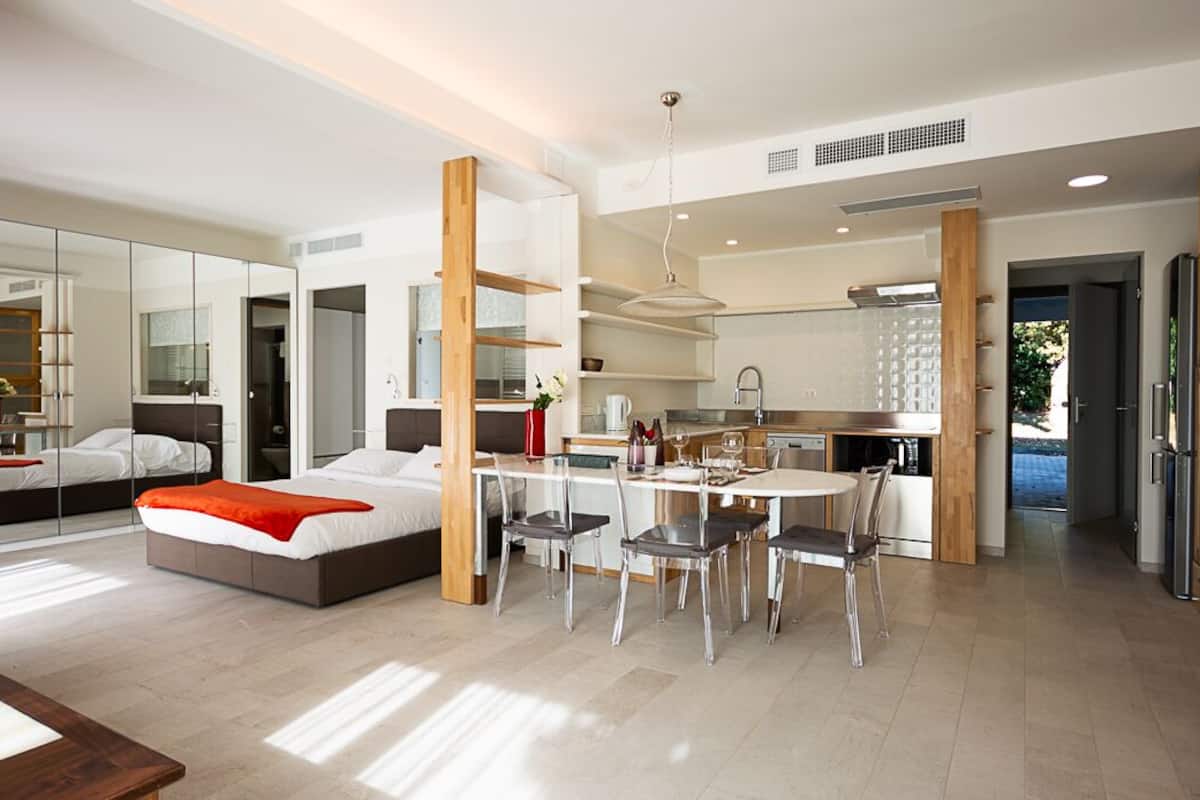 Une chambre d’hôtel moderne équipée d’un lit, d’un coin repas et d’une cuisine.