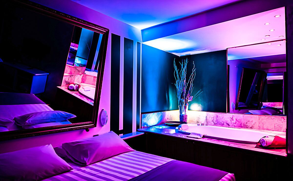 Un dormitorio moderno con una cama grande, un tocador con espejo y una mesita de noche.