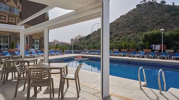 Een seizoensgebonden buitenzwembad en parasols bij het zwembad