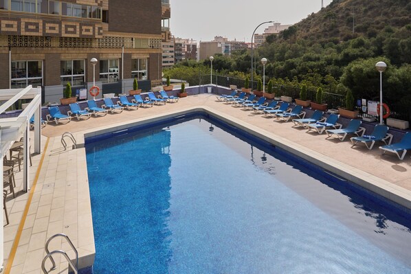 A rectangular swimming pool with blue water, surrounded by lounge chairs and potted plants. - Hotel Sercotel Maya Alicante (Alicante)