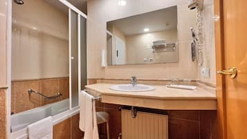 Un baño moderno con bañera, ducha y lavabo.