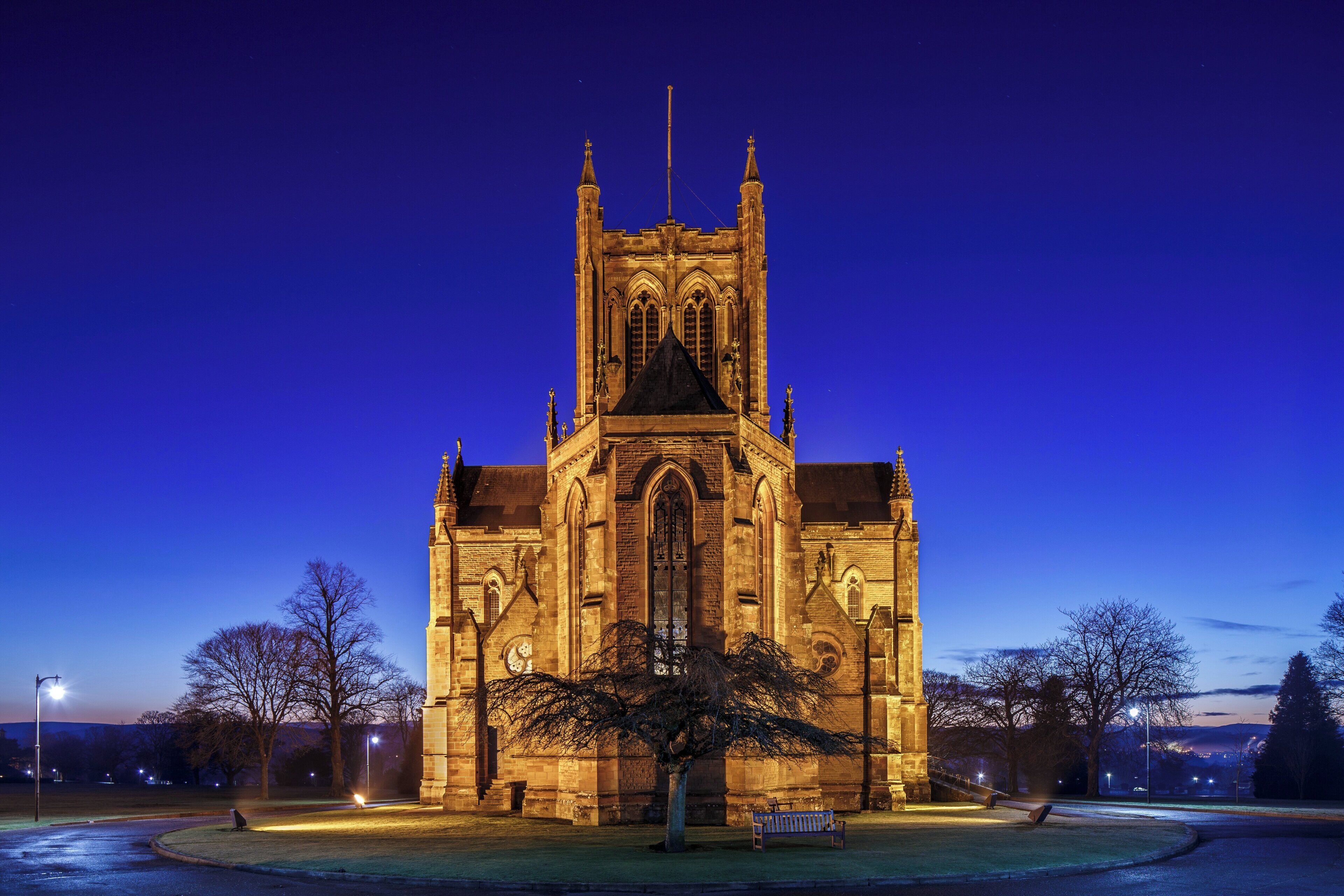 Una iglesia grande e iluminada con una torre destacada y arquitectura detallada.