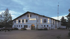 A white building with the name "GASTHOF" and "ULRICH MEYER" on the facade, featuring multiple windows and a large entrance.