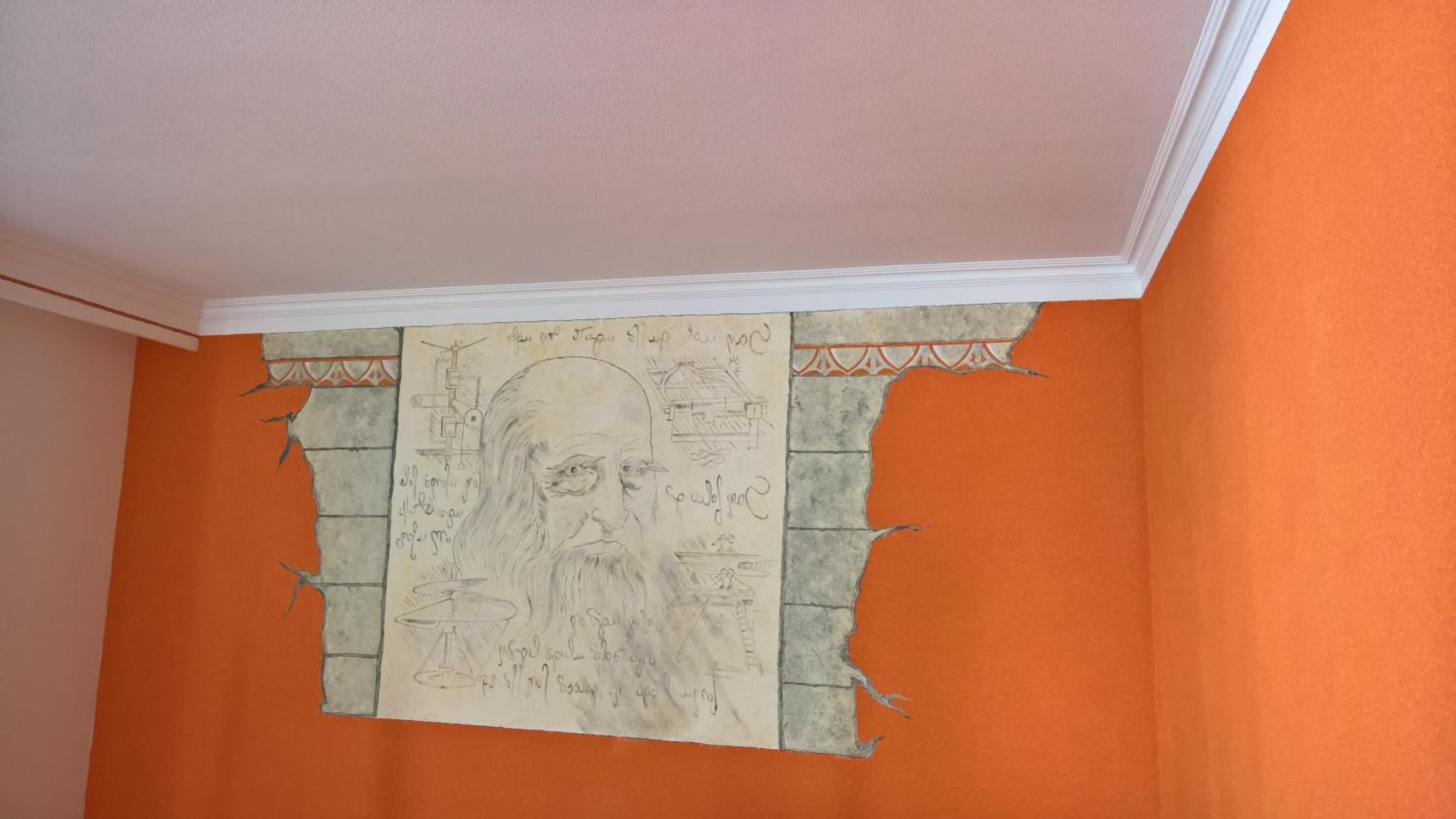 Una habitación con paredes anaranjadas y un techo con detalles blancos.
