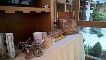 Ein Buffet mit gestapelten Tellern, Lebensmitteljaren und einer Holzeinrichtung.