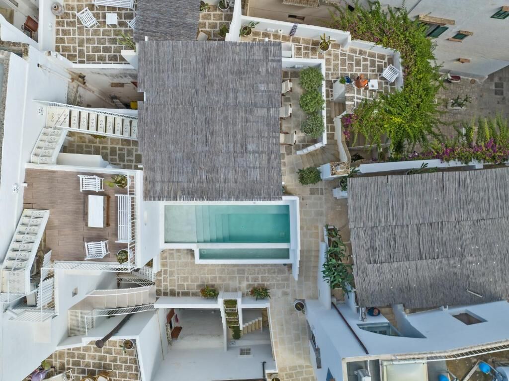 Un hôtel moderne doté d’une piscine sur le toit, de nombreux balcons et d’espaces de détente en plein air.