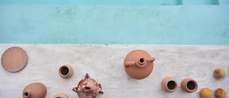 Diversos artículos de cerámica sobre una superficie cerca de una piscina.