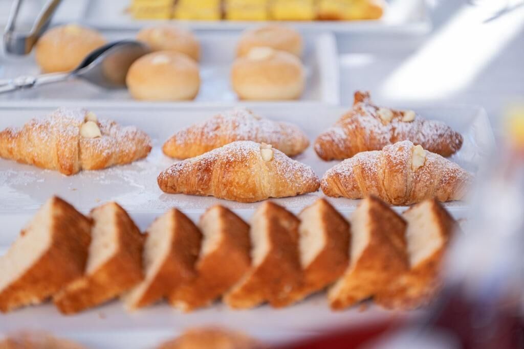 A variety of pastries, including croissants and other baked goods, displayed on a tray.