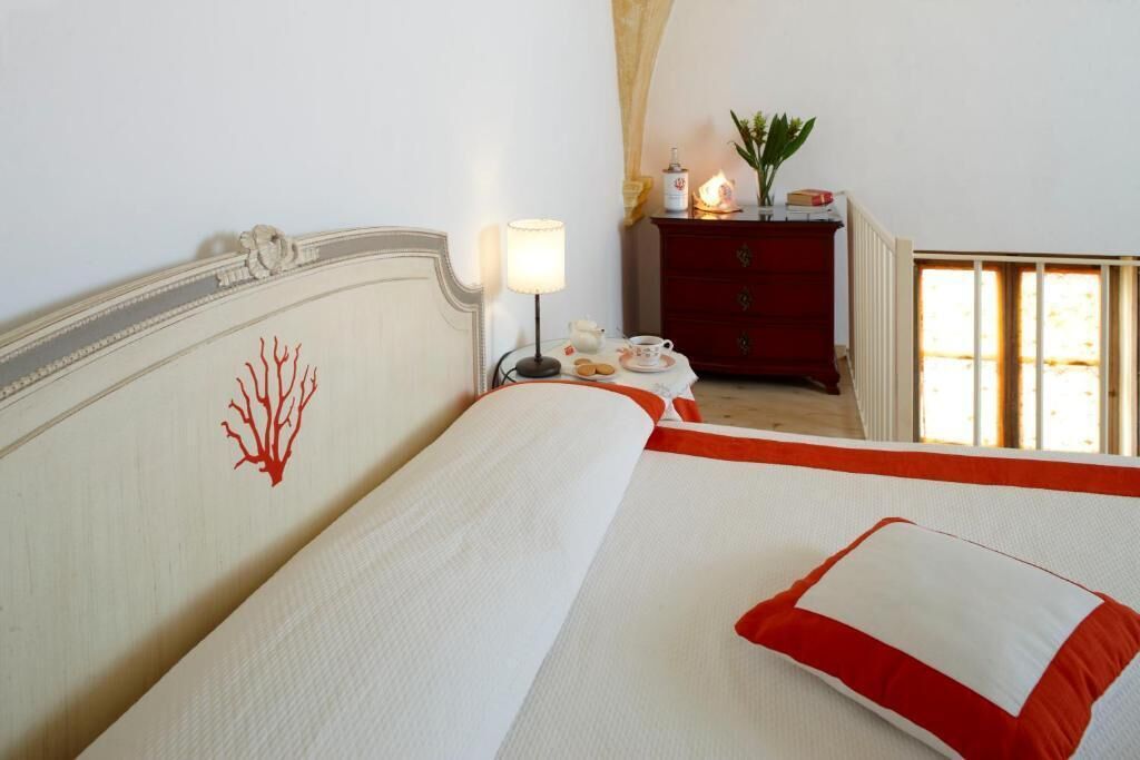 A hotel room with a bed, a nightstand, a dresser, and a window with curtains.