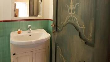 A bathroom with a white sink, a mirror, and a door with decorative patterns.