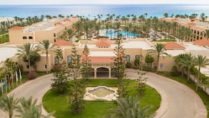 A resort with multiple buildings, a central pool, and a view of the ocean. - JAZ Almaza Beach Resort, Almaza Bay (Marsa Matrouh)