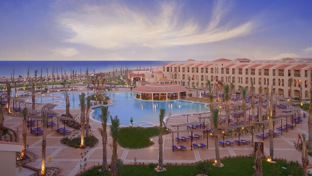 A resort with a large central pool, multiple guest rooms, and a beach view. - JAZ Almaza Beach Resort, Almaza Bay (Marsa Matrouh)