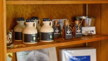 A shelf with various bottles and containers, including a few with labels that read "Pure Maple Syrup."