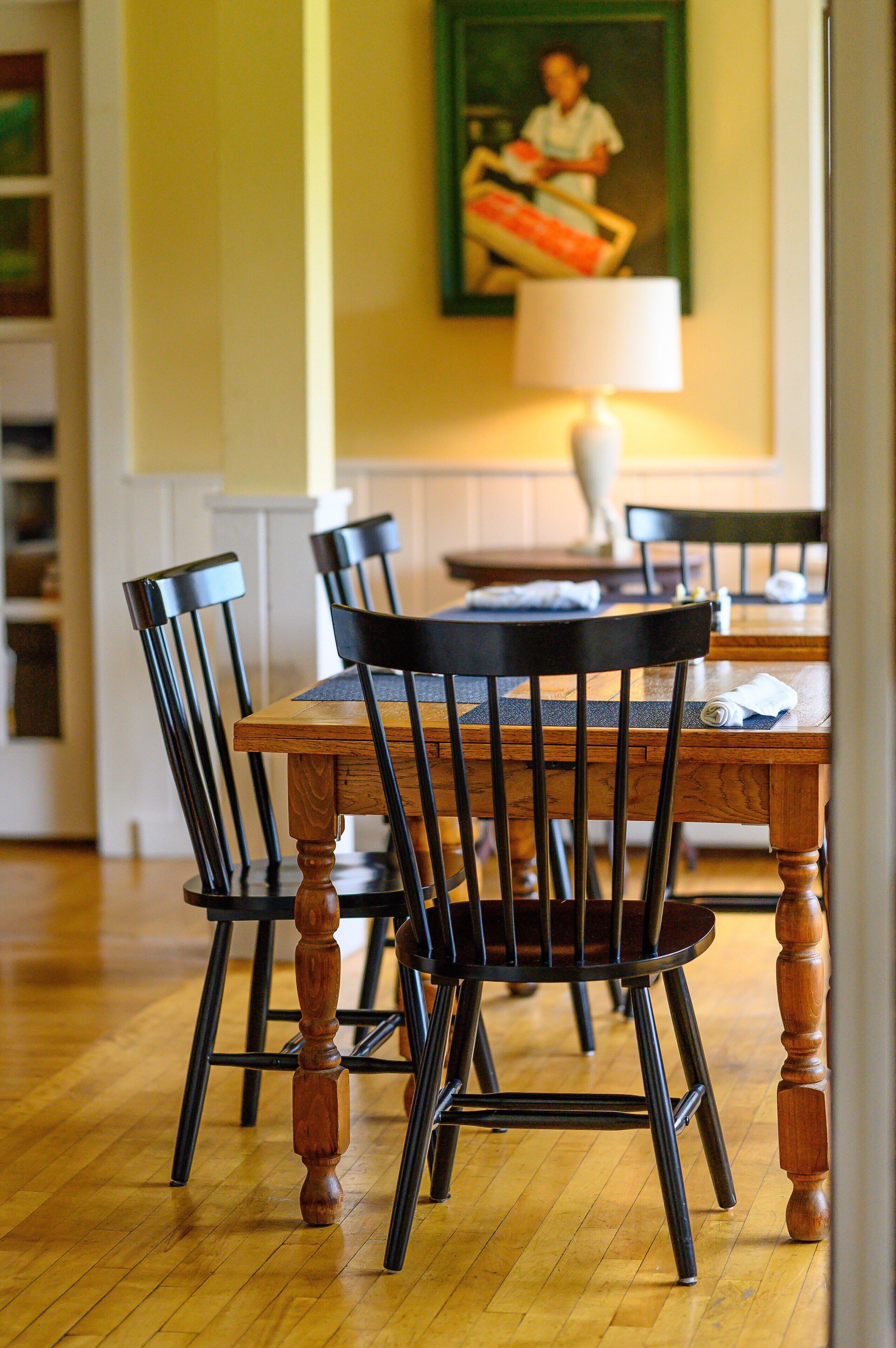 A dining area with a wooden table and black chairs.