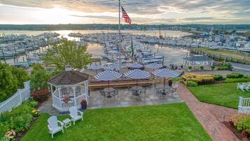 A marina with boats, a gazebo with outdoor seating, and a flagpole with an American flag.