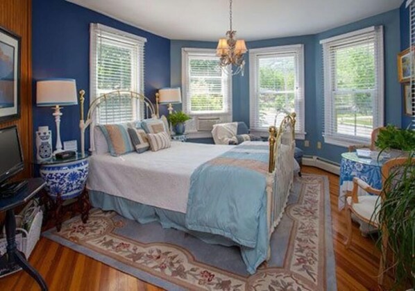A bedroom with a large bed, a television, and a desk with a chair. - Fairlawn Inn (Hunter)