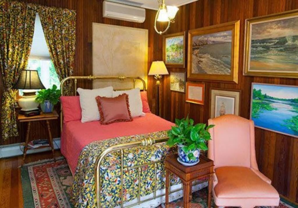 Une pièce avec un lit, une chaise, une lampe et une plante.