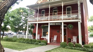 A two-story building with a balcony, labeled "BROSS HOTEL," featuring a traditional architectural style with white columns and a red brick facade. - Bross Hotel (Paonia)
