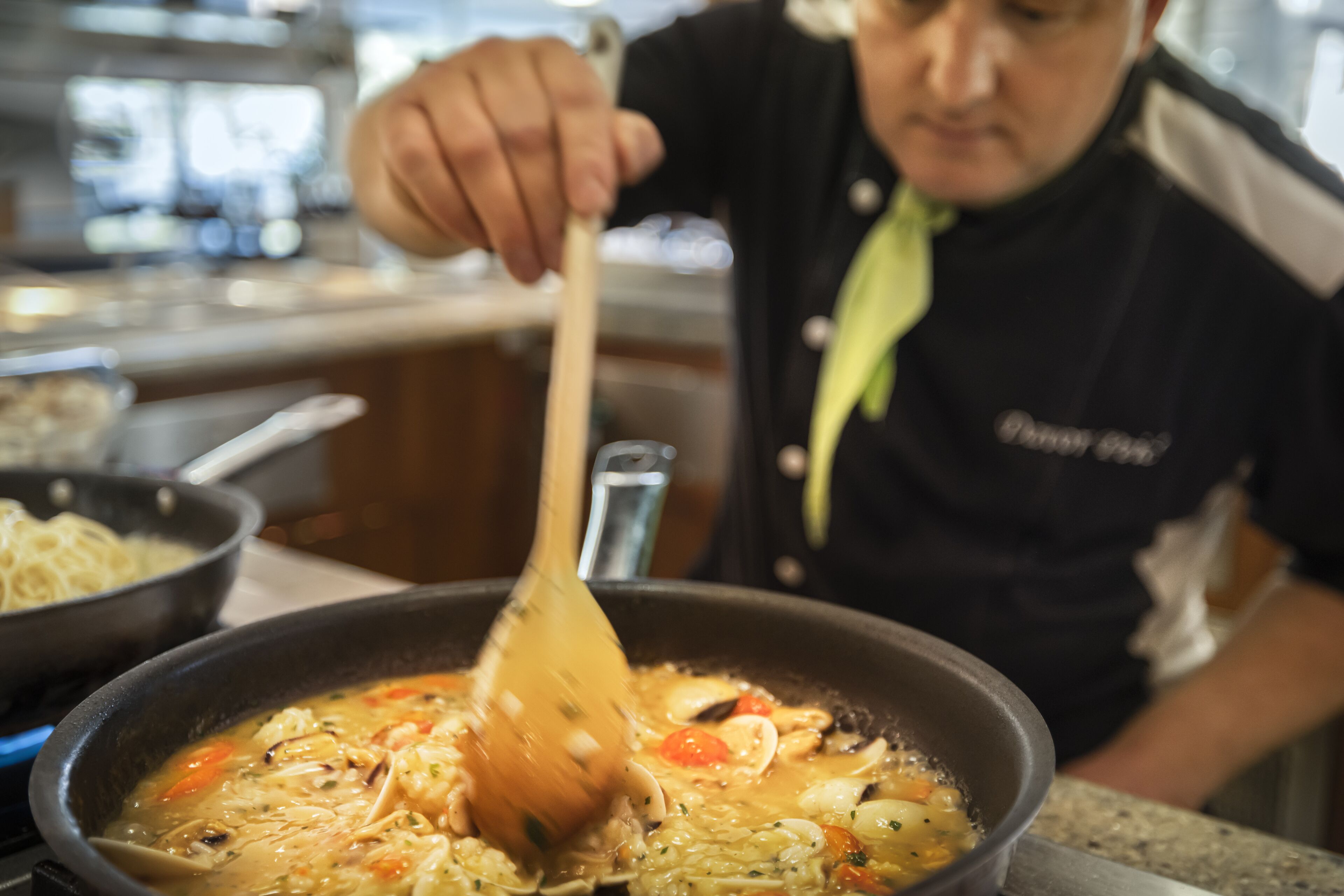 Una persona remenant una olla de sopa a la cuina.