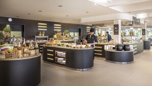Un moderno montaje tipo buffet con varias estaciones de servicio, una gran variedad de alimentos y una decoración interior limpia y contemporánea.