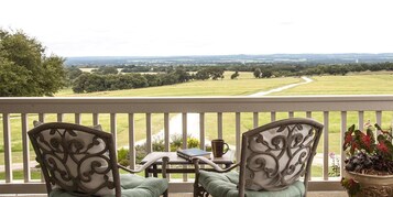 Een balkon met twee stoelen, een tafel en een bloempot.