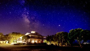 A house with a large porch, under a starry night sky.