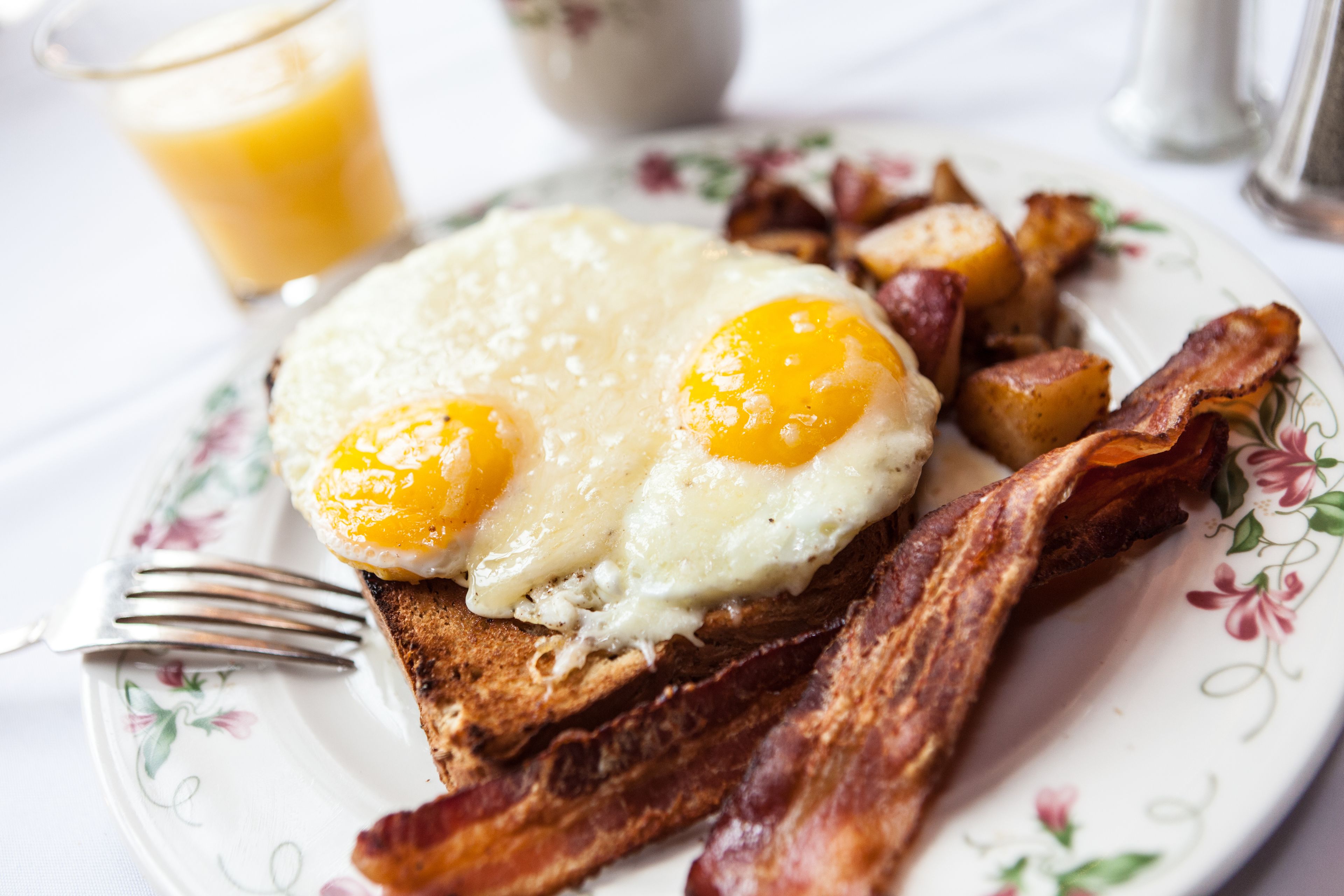Une assiette avec des œufs, du bacon et des pommes de terre.