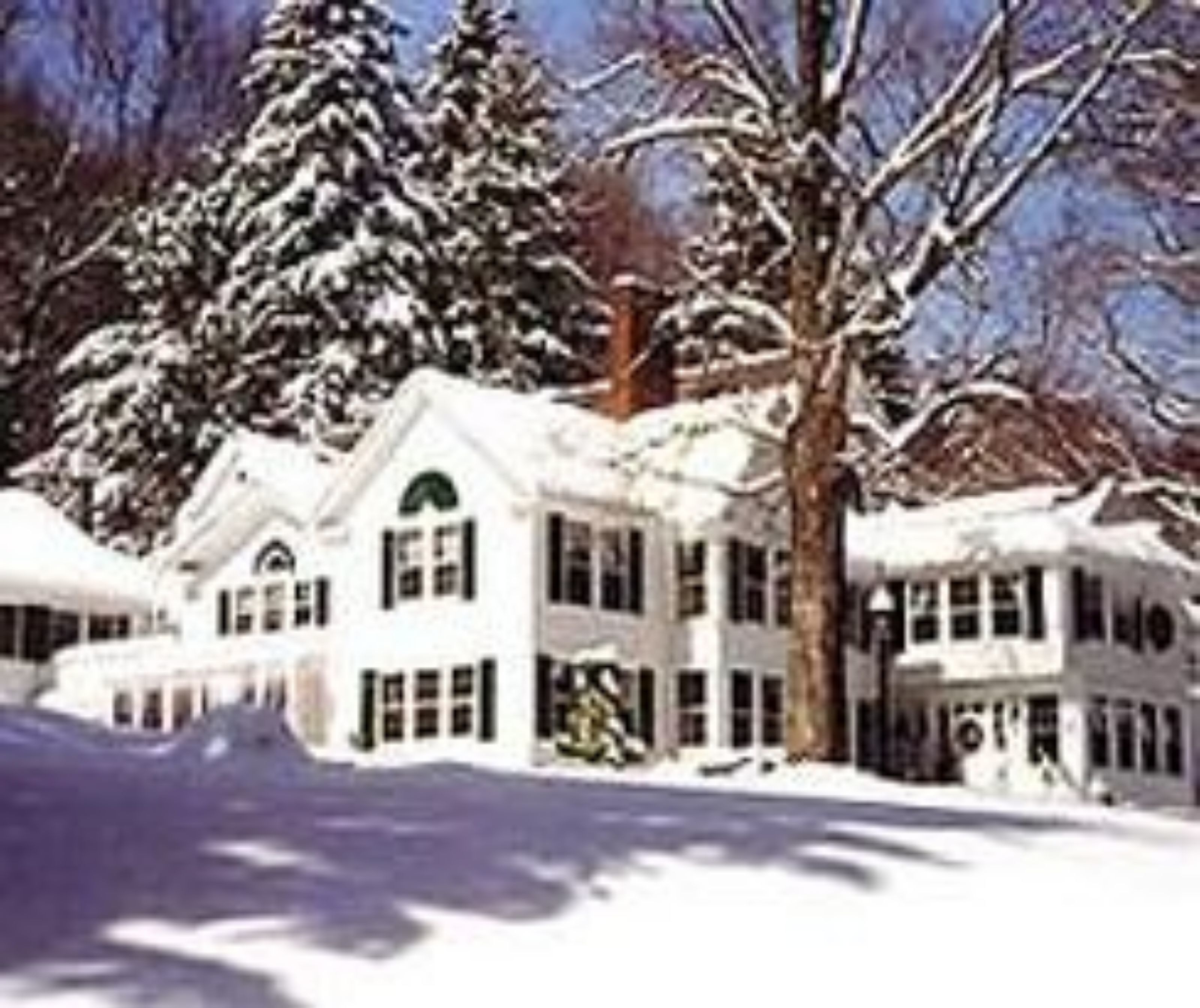 Un grand bâtiment recouvert de neige, doté de nombreuses fenêtres et d’une entrée imposante.