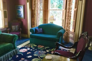 A room with a green sofa, a floral carpet, and a window with curtains. - Shaw House Inn (Ferndale)