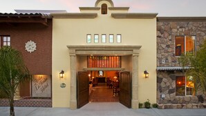 L'ingresso di un hotel con facciata in pietra, pavimento piastrellato e insegna con la scritta "Avila La Fonda Hotel".
