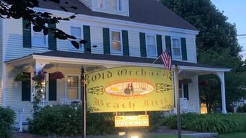 A two-story building with a porch, a sign for 'Old Orchard Beach Inn', and a 'No Vacancy' sign.