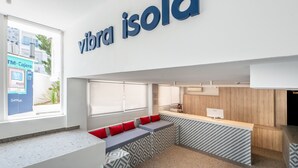 Un interior moderno con mostrador de recepción, zona de estar y un gran ventanal.