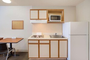 A compact kitchenette with a microwave, sink, and refrigerator. - WoodSpring Suites Jacksonville Beach Blvd (Jacksonville)
