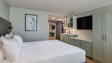 Un dormitorio moderno con una cama grande, un escritorio y una kitchenette.
