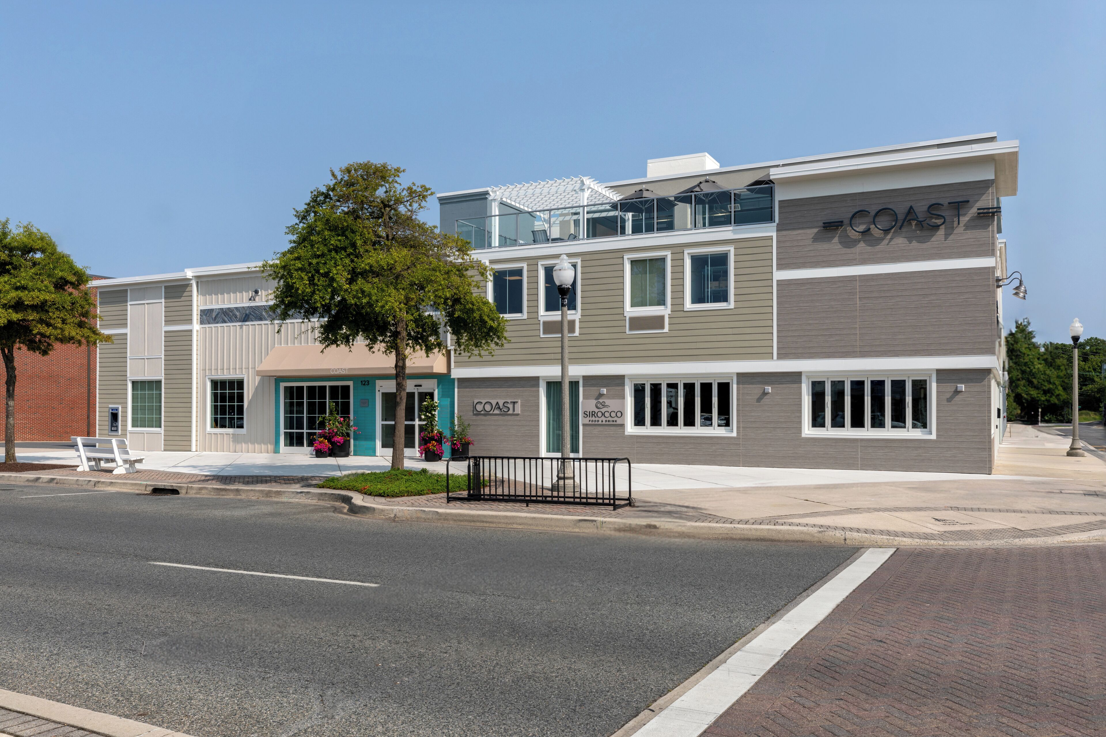 A two-story building with a sign reading "COAST" on the upper right side.