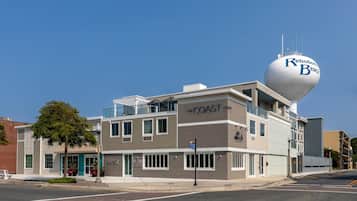 Un immeuble à plusieurs étages, surmonté d’un château d’eau bien visible portant l’inscription « Rehoboth Beach », et sur lequel on peut également voir une enseigne pour le restaurant « COAST ».