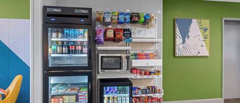 A vending area with various snacks and drinks, a microwave, and a refrigerator.