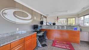 Zona de recepción con mostrador, computadora y señal de acceso para sillas de ruedas.