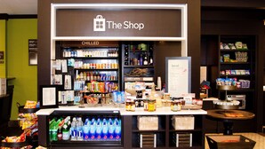 Un quiosco de bebidas frías llamado "The Shop" con una variedad de bebidas y aperitivos.