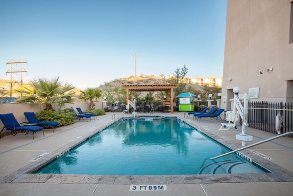 A swimming pool with lounge chairs and a pergola. - Hilton Garden Inn El Paso / University (El Paso)