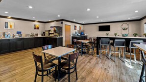 Un restaurant moderne avec un plancher en bois, une décoration en noir et blanc et un coin bar doté de tabourets.