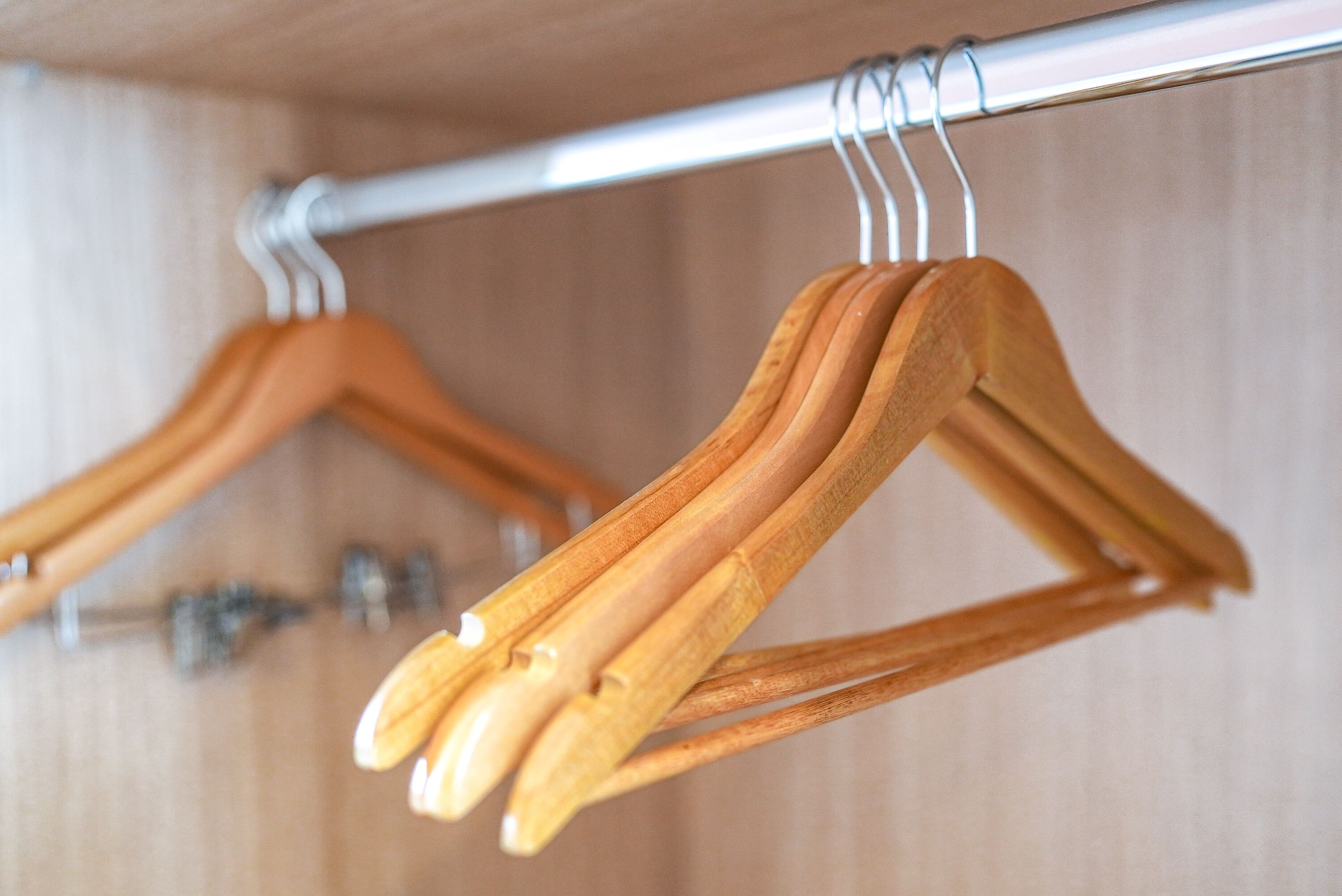 Wooden hangers hanging on a metal rod.